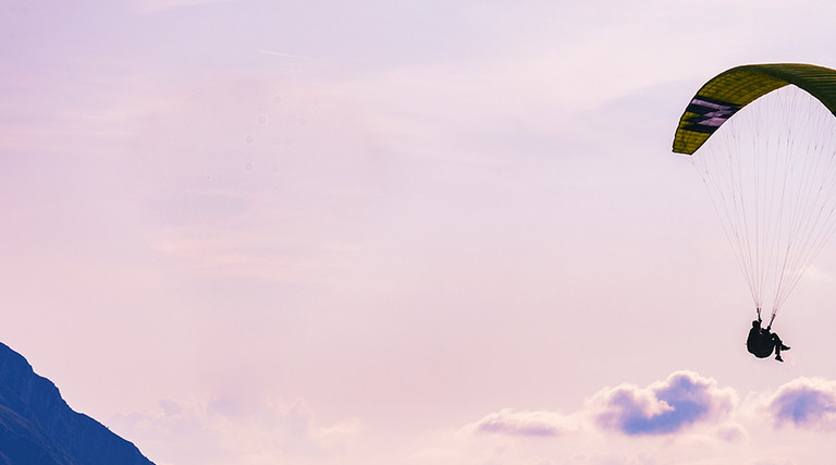 A person parachutes through the sky