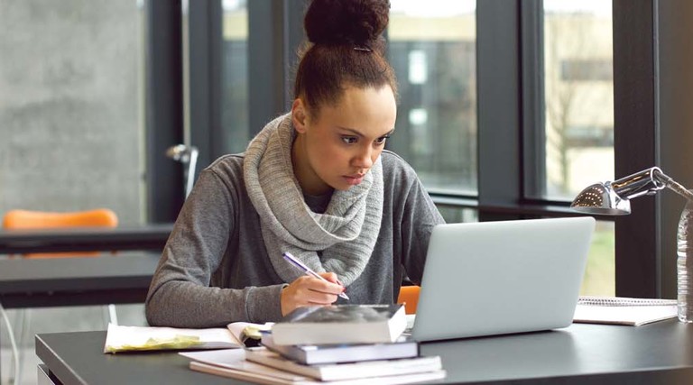 A woman works at her laptop