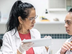 teacher helping a special needs student in a laboratory 