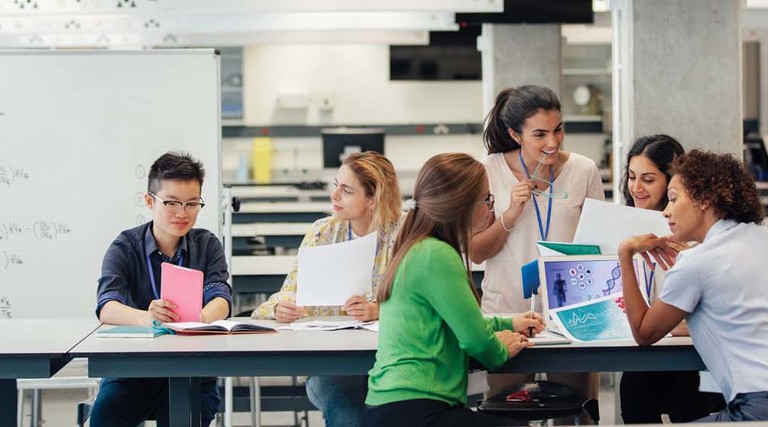 A group of women in a higher ed learning environment