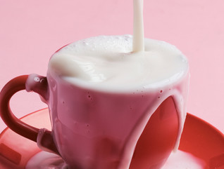 Liquid is poured into an overflowing coffee mug