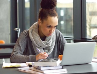 A woman works at her laptop