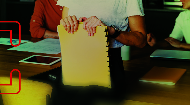 A person holds a notebook on their lap