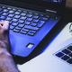 Hands working on two laptops