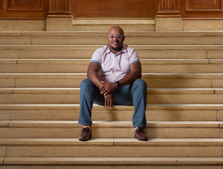 Curtis Cain sits on the steps of a building at Howard University