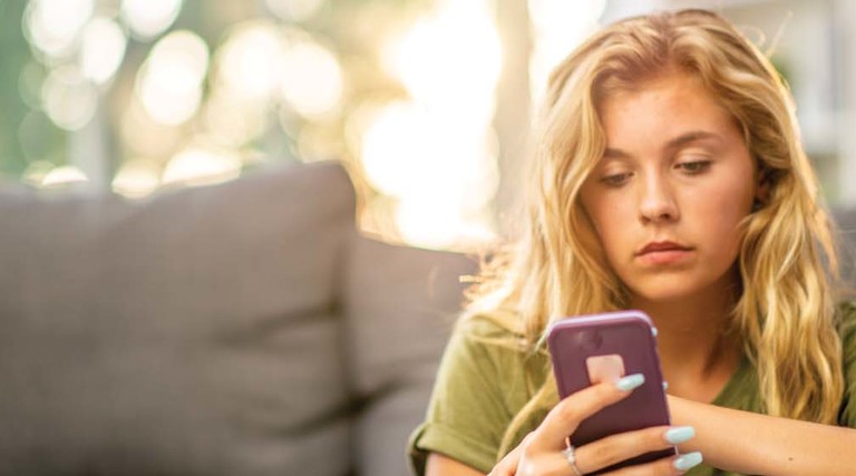 A woman looks at her cell phone