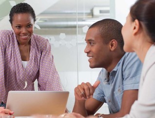 A diverse group of people around a conference room table.