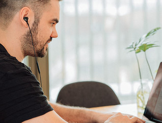 man wearing headphones on laptop