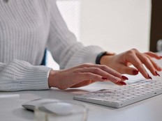 A woman types at a keyboard