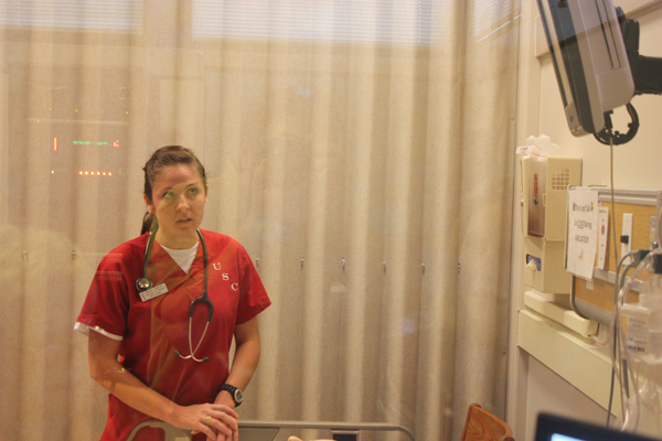 Student Rachael McElvie looks for the rhythm of the patient’s heart.