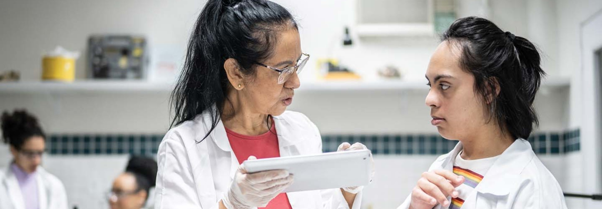 teacher helping a special needs student in a laboratory 
