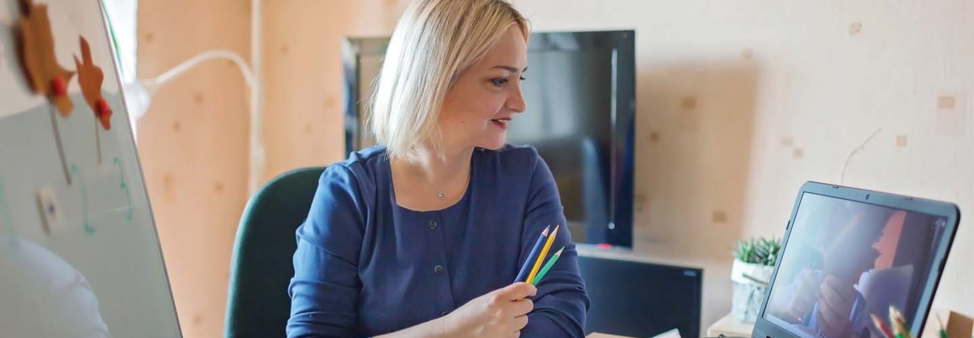 A woman working from home looks at her laptop