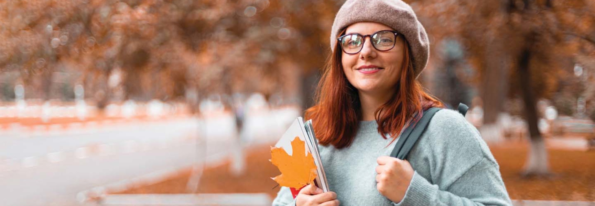 A young woman on a college campus in fall