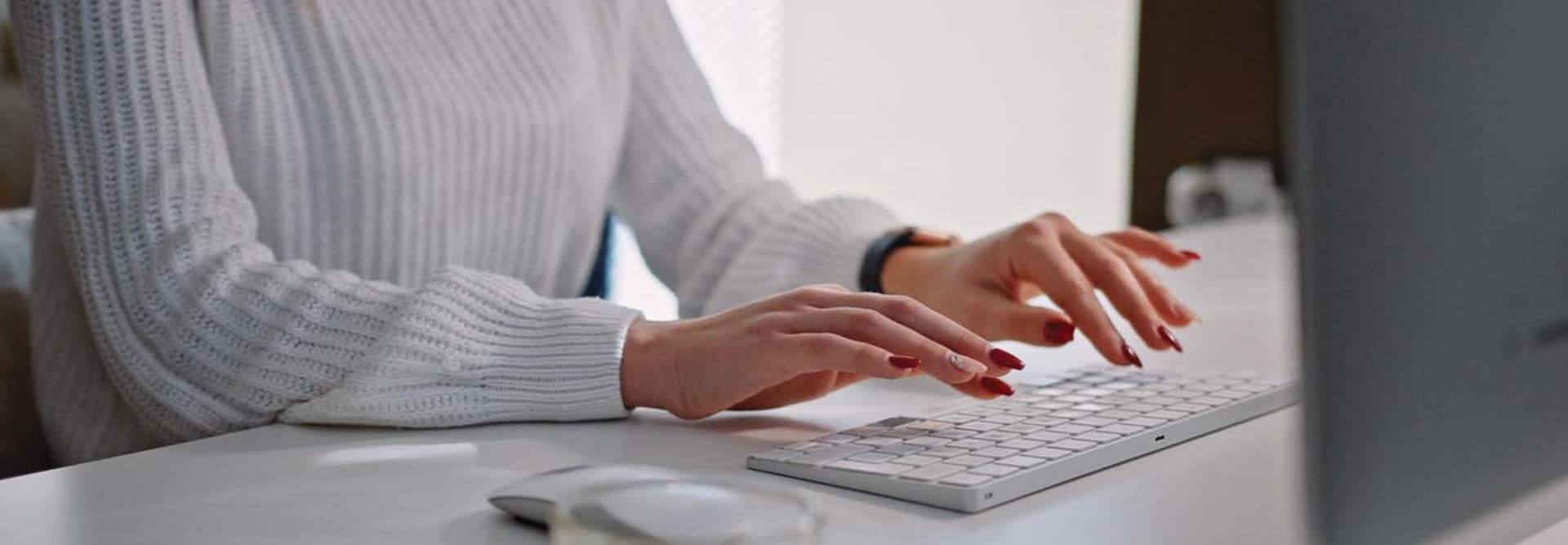 A woman types at a keyboard