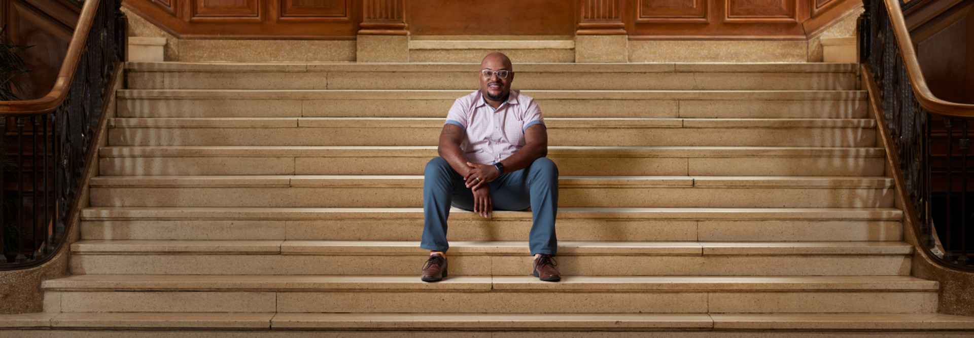 Curtis Cain sits on the steps of a building at Howard University
