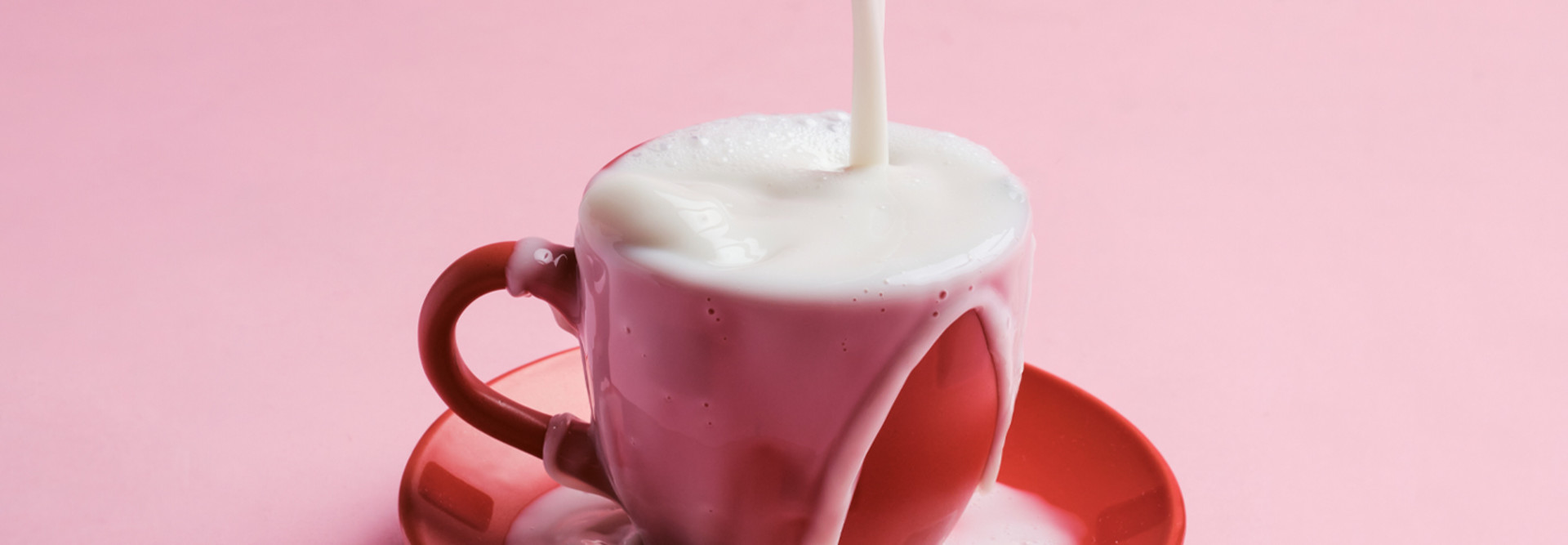 Liquid is poured into an overflowing coffee mug