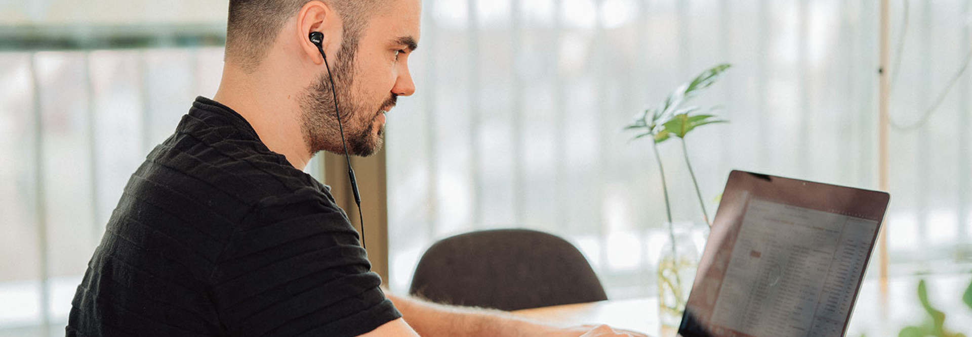 man wearing headphones on laptop