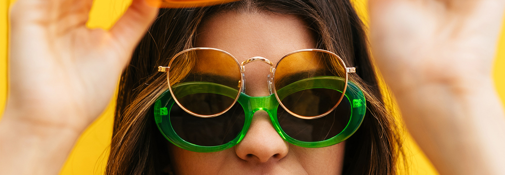A woman wearing two pairs of glasses