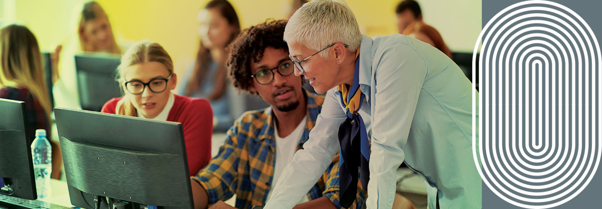 Teacher and students looking at a monitor in a classroom