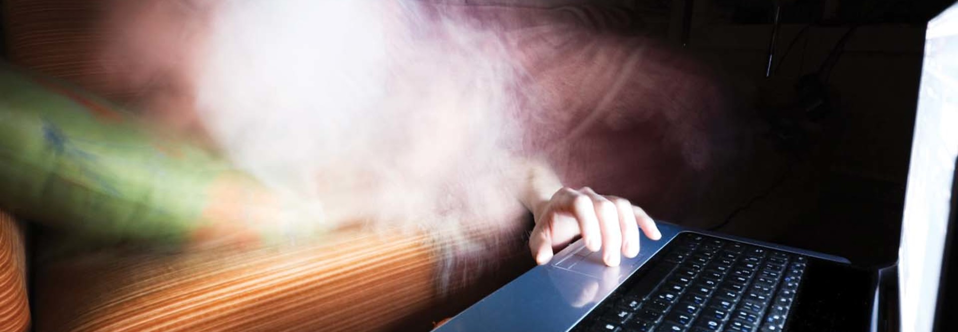 A phantom reaches a hand toward a laptop