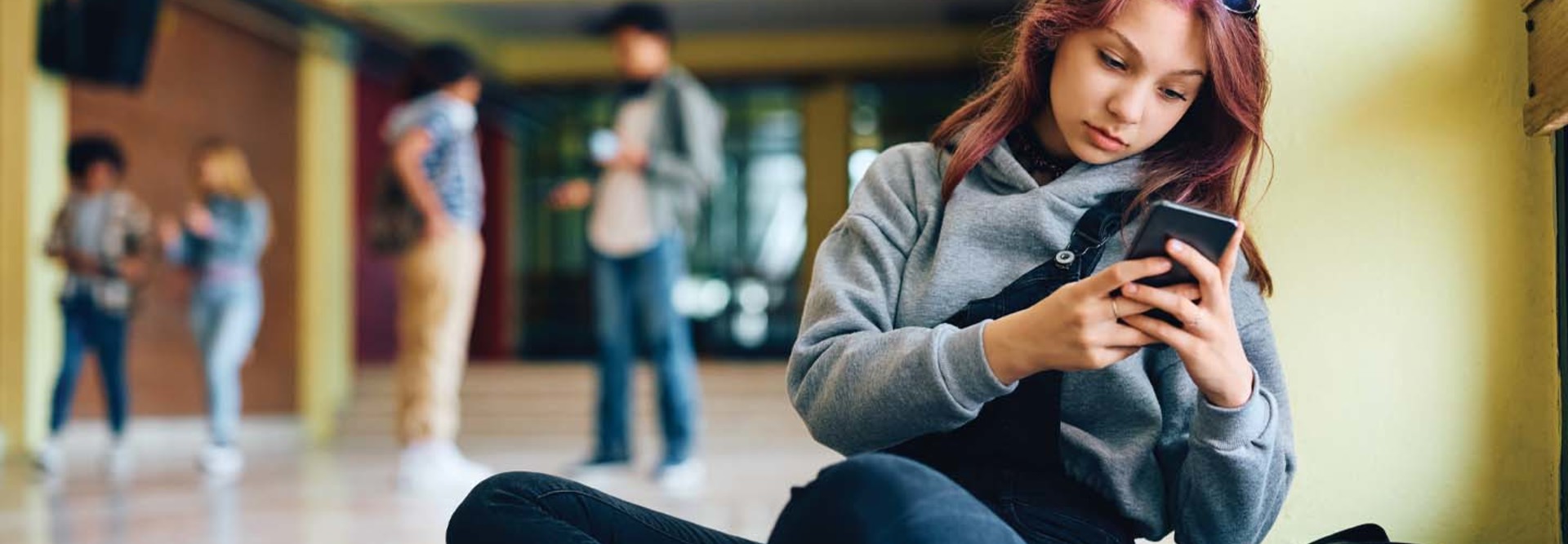 Student using phone in hallway