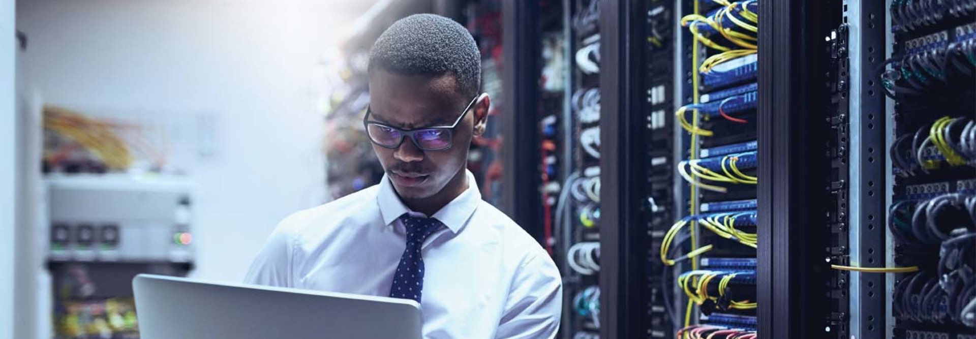 An IT worker on his laptop inside a data center