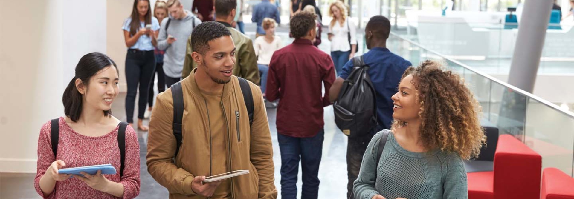 College students walk and talk in a crowded modern building