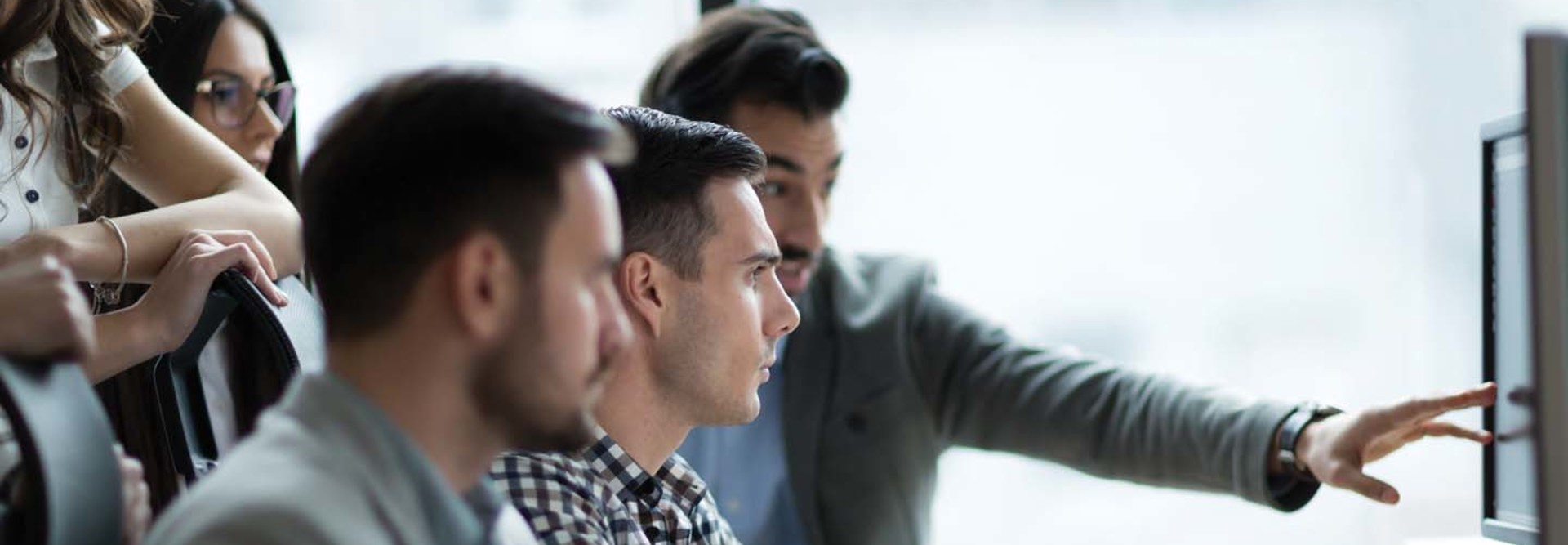 A group of coworkers reviewing a desktop