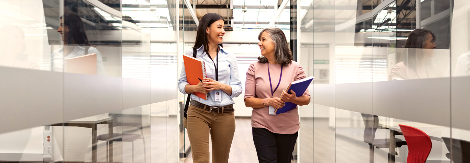 Two women chat about CIEM in an open hallway