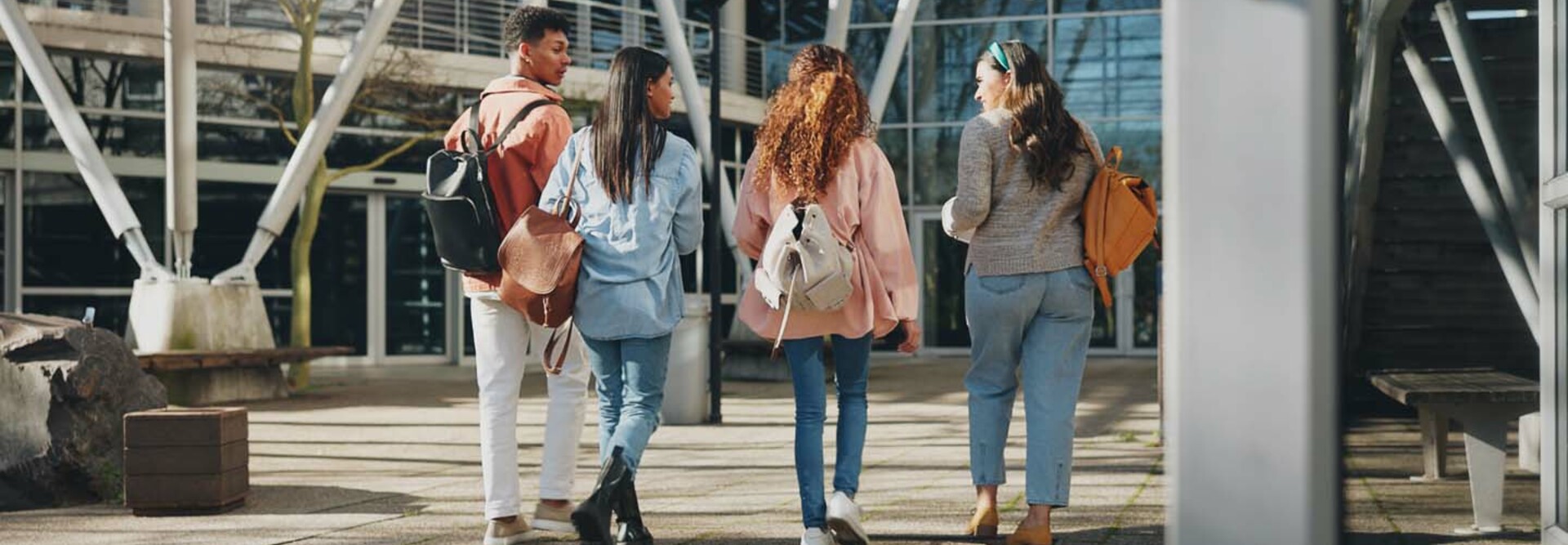 Rear angle photo of a group of students walking toward a campus building