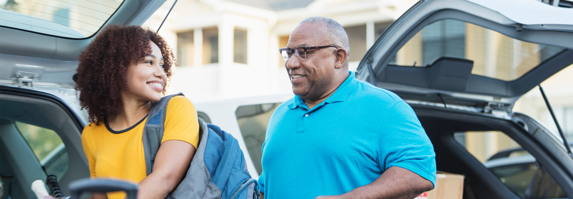A student and and older adult unload a car during college move-in day