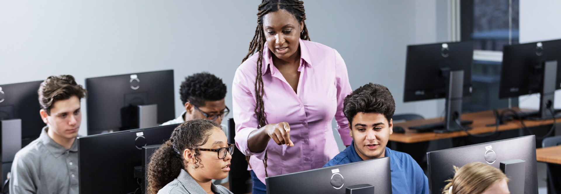 Teacher assisting students in computer lab