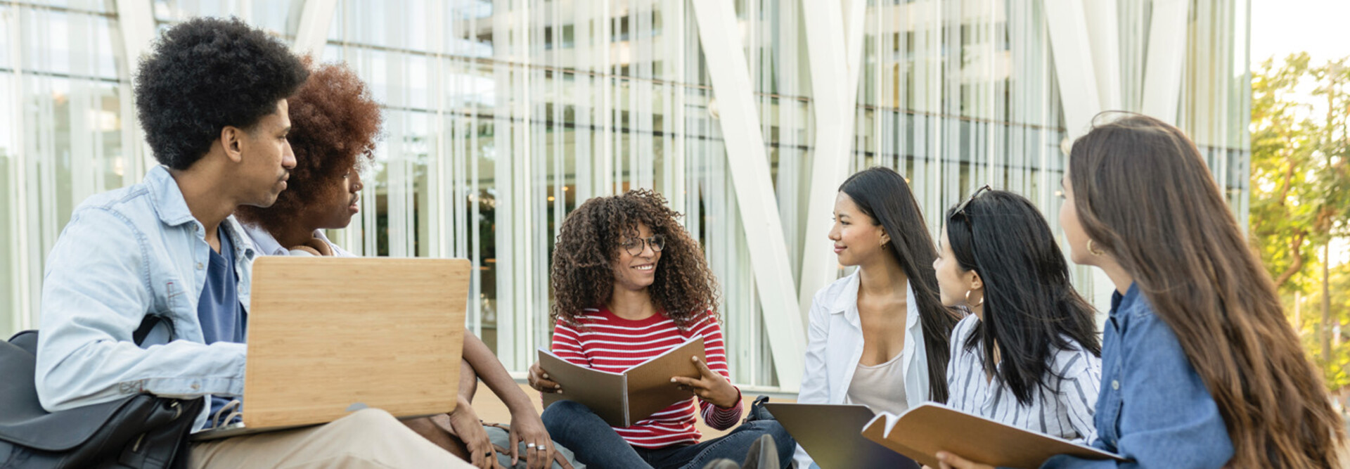 A group of students chat outside on a college campus