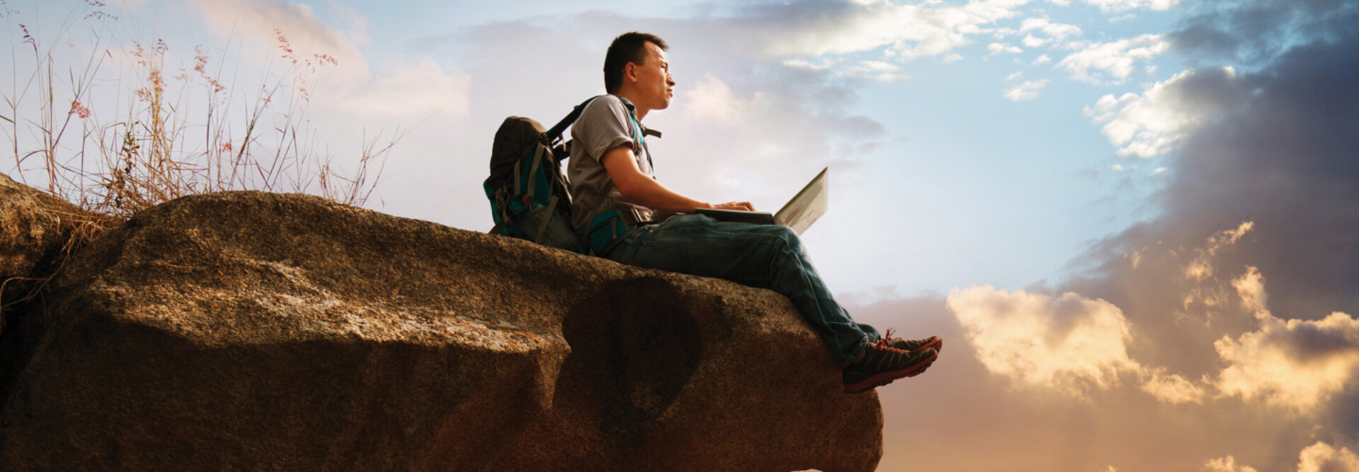 Student using laptop in the wilderness