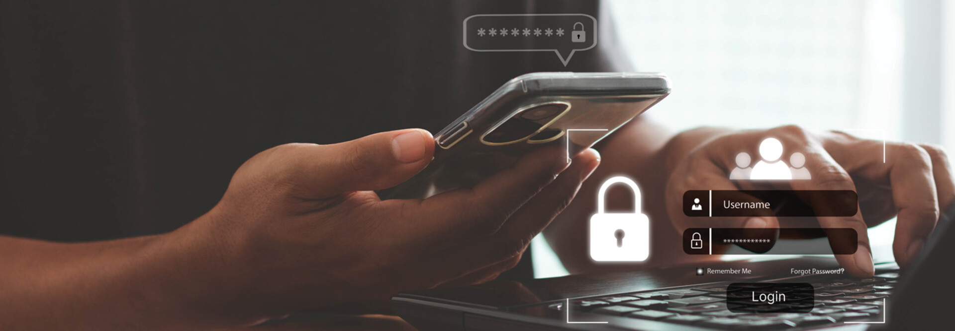 A person with a phone in one hand and their other hand on a keyboard, presumably to complete multifactor authentication