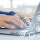 Person typing on laptop with overlay of icons