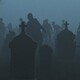 Silhouetted zombies rise from a foggy graveyard