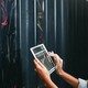 A woman holding a tablet inspects a cabinet of servers