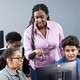 Teacher assisting students in computer lab