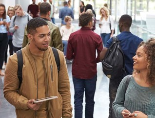 College students walk and talk in a crowded modern building