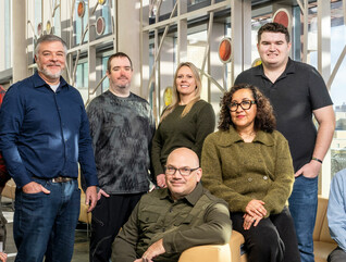 A team of IT employees at the Universities of Wisconsin pose for a photo.