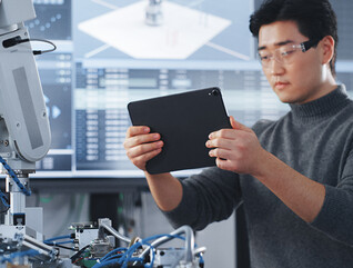 Student Holding Tablet and Controlling Robot Hand Moving at Different Ways At University Class