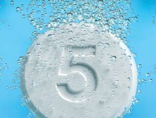 Tablets with the number five on them dropping into liquid and fizzing