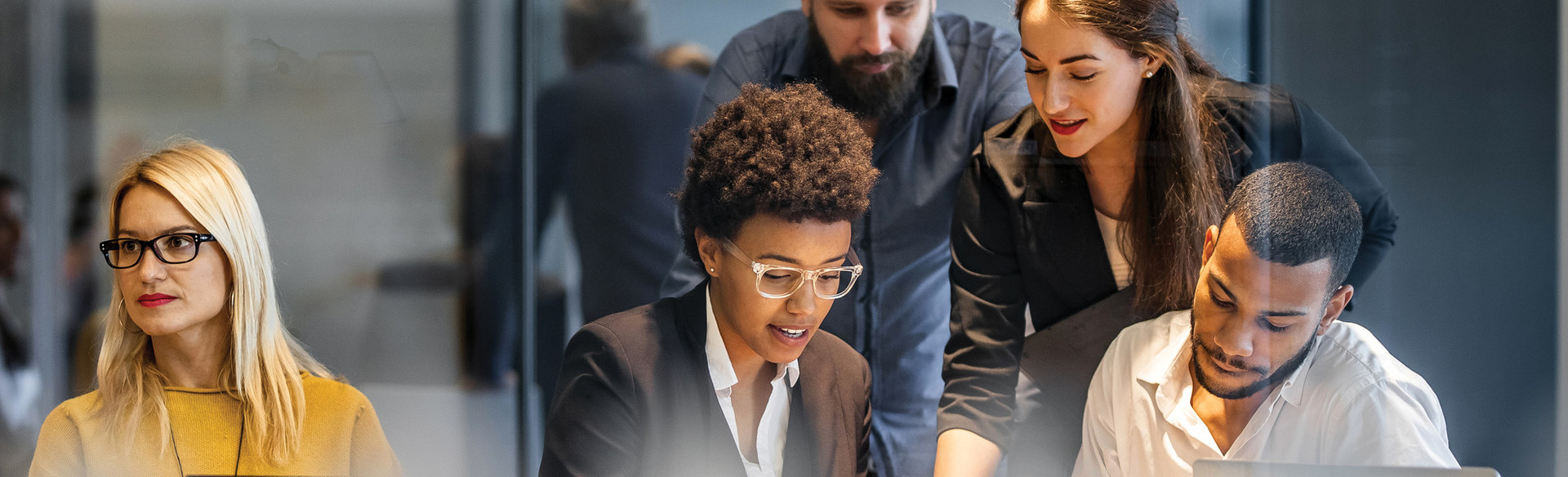 A group of people look down at a table and work together