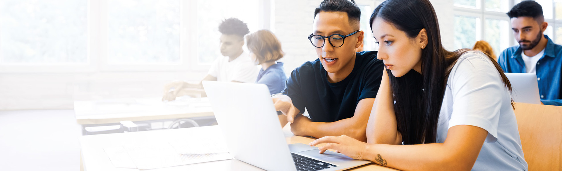 Students look at a laptop