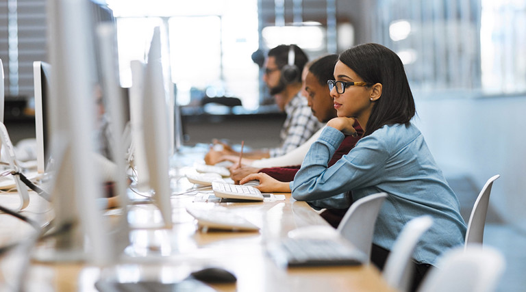 College students using computers in a library 