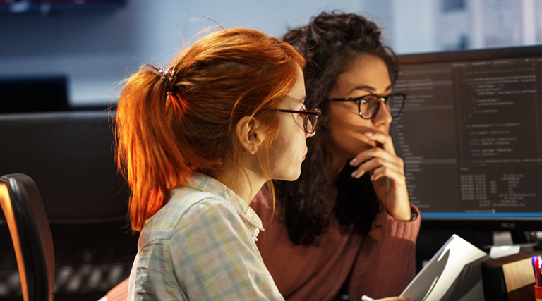 Two women staring at a computer