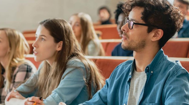 Students in a lecture hall listen intently
