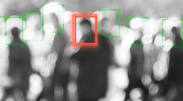 A blurred crowd of people whose faces are being scanned by an unseen camera