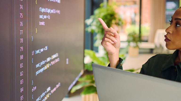Person analyzing code on laptop